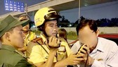 A traffic police officer measures breath alcohol concentration of a driver. (Photo: Sggp)