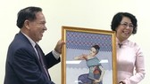 Chairman of the Lao Front for National Construction – Vientiane chapter Bounthieng Khounsy (L) presents a picture to To Thi Bich Chau, Vice President of the Vietnam Fatherland Front – Ho Chi Minh City chapter (Source: daidoanket.vn)