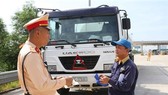 A member of the traffic police checks the paperwork of a truck driver on the Hanoi-Hai Phong Expressway. (Photo: VNA)