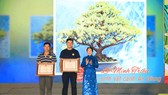 Deputy Secretary of the municipal Party Committee Vo Thi Dung presents two special prizes to artisans. (Photo: SGGP)
