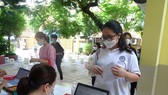 A healthcare worker collect information of a student before taking sample for Covid 19-testing (Photo: SGGP)