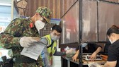 Military forces help local residents shop for food during the stricter social distancing measures. (Photo: SGGP)