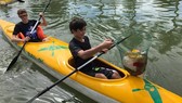 Foreign visitors take the clean-up tour collecting trash while kayaking on the Hoai River.