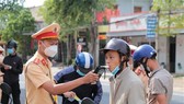 A traffic officer of Phu Thien district, the Central Highlands province of Gia Lai, administering a breathalyser test on a road user during rush hour. (Photo: VNA)