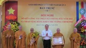 Vice Secretary of the Party Committee of HCMC Nguyen Ho Hai hands over a certificate of merit from the Prime Minister to the Executive Board of the Vietnam Buddhist Sangha (VBS) of District 3 .