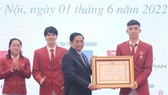 Prime Minister Pham Minh Chinh (front, left) presents a second-class Labor Order to swimmer Nguyen Huy Hoang. (Photo: VNA)