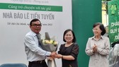 Ms. Dinh Thi Thanh Thuy, Director of the HCMC General Publishing House (C) and former Vice Secretary of the Party Committee and former Chairwoman of the People's Council of HCMC Pham Phuong Thao (R) congratulate Journalist Le Tien Tuyen.