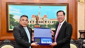 Chairman of the HCMC People’s Committee Phan Van Mai (R) offers a gift to Philippine Ambassador to Vietnam, Meynardo LB. Montealegre. (Photo: SGGP)