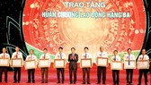 Head of the Central Economic Commission, Tran Tuan Anh (C) hands over Third Class Labor Medal s to ten outstanding farmers. (Photo: VNA)
