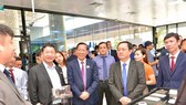 Chairman of the HCMC People’s Committee Phan Van Mai (3rd, L) and and Minister of Science and Technology Huynh Thanh Dat (2nd, R) visit a display booth of high-tech products at the event.