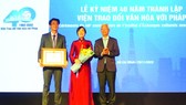 Vice Chairman of the municipal People’s Committee Vo Van Hoan (R) congratulates the Institute of Cultural Exchange with France (IDECAF) in HCMC on the occasion of its 40th founding anniversary.
