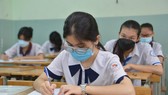 Thí sinh điền thông tin trước giờ làm bài thi môn Ngữ văn tại điểm thi Trường THCS Colette. Ảnh: CAO THĂNG
