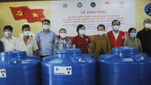 Phu nhân nguyên Chủ tịch nước Trương Tấn Sang (từ trái qua, người thứ 5) trao tặng 100 bồn chứa nước ngọt cho bà con nghèo tại xã Nam Thái A. Ảnh: TÍN HUY