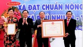Chủ tịch UBND tỉnh Bến Tre Trần Ngọc Tam (bên trái, thứ 2) trao bằng công nhận xã nông thôn mới nâng cao cho lãnh đạo xã Phú Nhuận