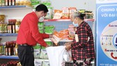 Chủ tịch Hội Chữ thập đỏ TPHCM Trần Trường Sơn giúp người dân chọn hàng tại Phiên chợ nhân đạo tại huyện Nhà Bè
