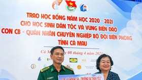 Đại tá Nguyễn Quang Hà, Phó Chính ủy Bộ Chỉ huy Bộ đội Biên phòng tỉnh Cà Mau nhận bảng tượng trưng 100 suất học bổng trị giá 100 triệu đồng do bà Trương Mỹ Hoa trao tặng. Ảnh: BĂNG THANH