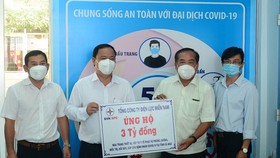 Giám đốc Công ty Điện lực Cà Mau Huỳnh Hữu Quang (thứ 2 từ trái sang), đại diện Tổng Công ty Điện lực miền Nam trao bảng tượng trưng số tiền hỗ trợ cho Ủy ban MTTQ Việt Nam tỉnh Cà Mau. Ảnh: NGỌC HÂN