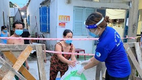 Tình nguyện viên đến trao nhu yếu phẩm từ "Chợ Nghĩa Tình"