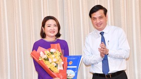 Phó Chủ tịch UBND TPHCM Lê Hòa Bình trao quyết định cho bà Bùi Thị Ngọc Hiếu. Ảnh: VIỆT DŨNG