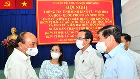 Chủ tịch nước Nguyễn Xuân Phúc trao đổi cùng các đồng chí lãnh đạo TPHCM tại hội nghị. Ảnh: VIỆT DŨNG