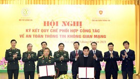 Lieutenant General Dinh The Cuong and Head of AIS Nguyen Thanh Phuc are signing the Regulation. (Photo: SGGP)
