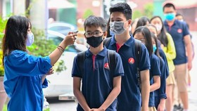 Temperature screening of students in front of schools aims to detect Covid-19 infections (Photo: SGGP)