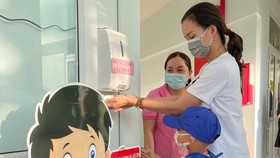 Các bé Trường Mầm non Tuổi Thơ (quận 8) được hướng dẫn vệ sinh, khử khuẩn trước khi vào lớp. Ảnh: HOÀNG HÙNG