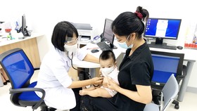 Người dân đưa trẻ đi tiêm chủng tại VNVC Bình Phước