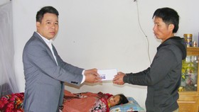 Thay mặt Báo SGGP, ông Nguyễn Bá Long, Bí thư Đảng ủy xã Đông Quang (Đông Sơn, Thanh Hóa) trao tiền của bạn đọc báo cho anh Lê Duy Thủy