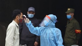 A man has his body temperature checked. (Photo: VNA)