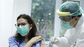 Nhân viên y tế tiêm phòng dịch COVID-19 cho người dân tại Jakarta, Indonesia. Ảnh: THX/TTXVN