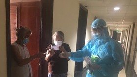 Đo thân nhiệt và trao tận tay phiếu cử tri bầu cử đại biểu Quốc hội và Hội đồng nhân dân các cấp nhiệm kỳ 2021-2026 cho từng công dân đang cách ly tập trung 