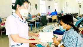 Phó Chủ tịch Hội Hộ sinh TPHCM Nguyễn Thị Tuyết Hằng trao quà hỗ trợ sản phụ Nguyễn Thị Thanh Nga