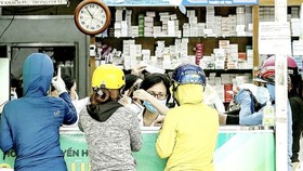 Người dân mua thuốc hỗ trợ điều trị Covid-19 tại một cửa hàng thuốc ở quận 4. Ảnh: HOÀNG HÙNG