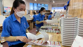 Công nhân Công ty cổ phần In số 7 phấn khởi chờ thưởng tết. Ảnh: HỒNG HẢI
