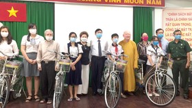 Chị Đặng Thị Minh Nguyệt (thứ tư, từ trái sang) tặng phương tiện đi học cho học sinh, sinh viên hoàn cảnh khó khăn