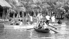 Du khách chèo xuồng vui chơi ở Làng du lịch Mỹ Khánh