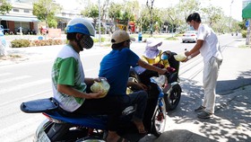 Anh Trương Vĩnh Đặng (35 tuổi, giáo viên dạy mỹ thuật Trường Tiểu học Tây Hồ) tặng bữa ăn cho người khuyết tật nghèo