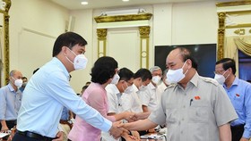Chủ tịch nước Nguyễn Xuân Phúc trao đổi cùng lãnh đạo TPHCM. Ảnh: Việt Dũng.