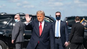 Ông Donald Trump vẫy tay chào sau khi hạ cánh xuống Sân bay Quốc tế Palm Beach ở West Palm Beach Fla., Vào ngày 20 tháng 1 năm 2021. (Alex Edelman / AFP qua Getty Images)
