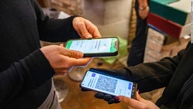 Khách hàng trình thẻ xanh COVID-19 tại một nhà hàng ở Ý. Ảnh: CNN.