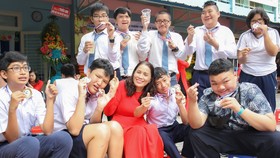 Cô Lê Thị Kim Chi, Giám đốc Trung tâm Hỗ trợ phát triển giáo dục hòa nhập Tân Bình (quận Tân Bình) cùng các học trò của mình. Ảnh: HOÀNG HÙNG