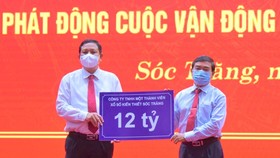 Ông Lê Văn Khanh, Chủ tịch Công ty XSKT Sóc Trăng (phải) trao 12 tỷ đồng hỗ trợ xây dựng nhà ở cho hộ nghèo