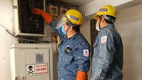 Nhân viên ngành điện thành phố kiểm tra hệ thống điện cho khách hàng