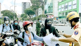 Kiểm tra giấy đi đường tại giao lộ Nguyễn Thị Minh Khai - Cách Mạng Tháng Tám, quận 3, TPHCM vào trưa 15-9. Ảnh: CHÍ THẠCH
