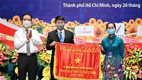 Phó Giám đốc Sở Văn hóa và Thể thao TPHCM Võ Trọng Nam trao tặng Cờ Truyền thống của UBND TPHCM cho Hội Nhiếp ảnh TP. Ảnh: hcmcpv