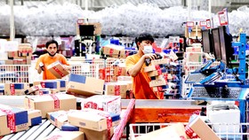 Nhân viên tại một kho hàng ở Indonesia kiểm tra hàng hóa đặt trên sàn thương mại điện tử