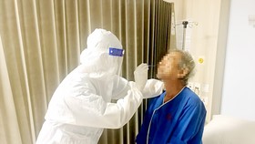 Nhân viên Bệnh viện Gia An 115 lẫy mẫu xét nghiệm sàng lọc SARS-CoV-2 cho người bệnh vào đêm 12-5