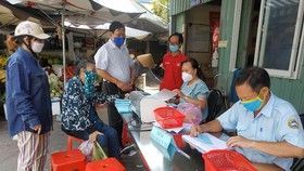 Người đi chợ Bình Thới khai báo y tế trước khi nhận phiếu đi chợ theo thứ tự