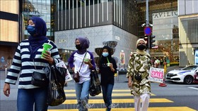 Người dân đeo khẩu trang phòng lây nhiễm SARS-CoV-2 tại Kuala Lumpur, Malaysia. Ảnh: THX/TTXVN